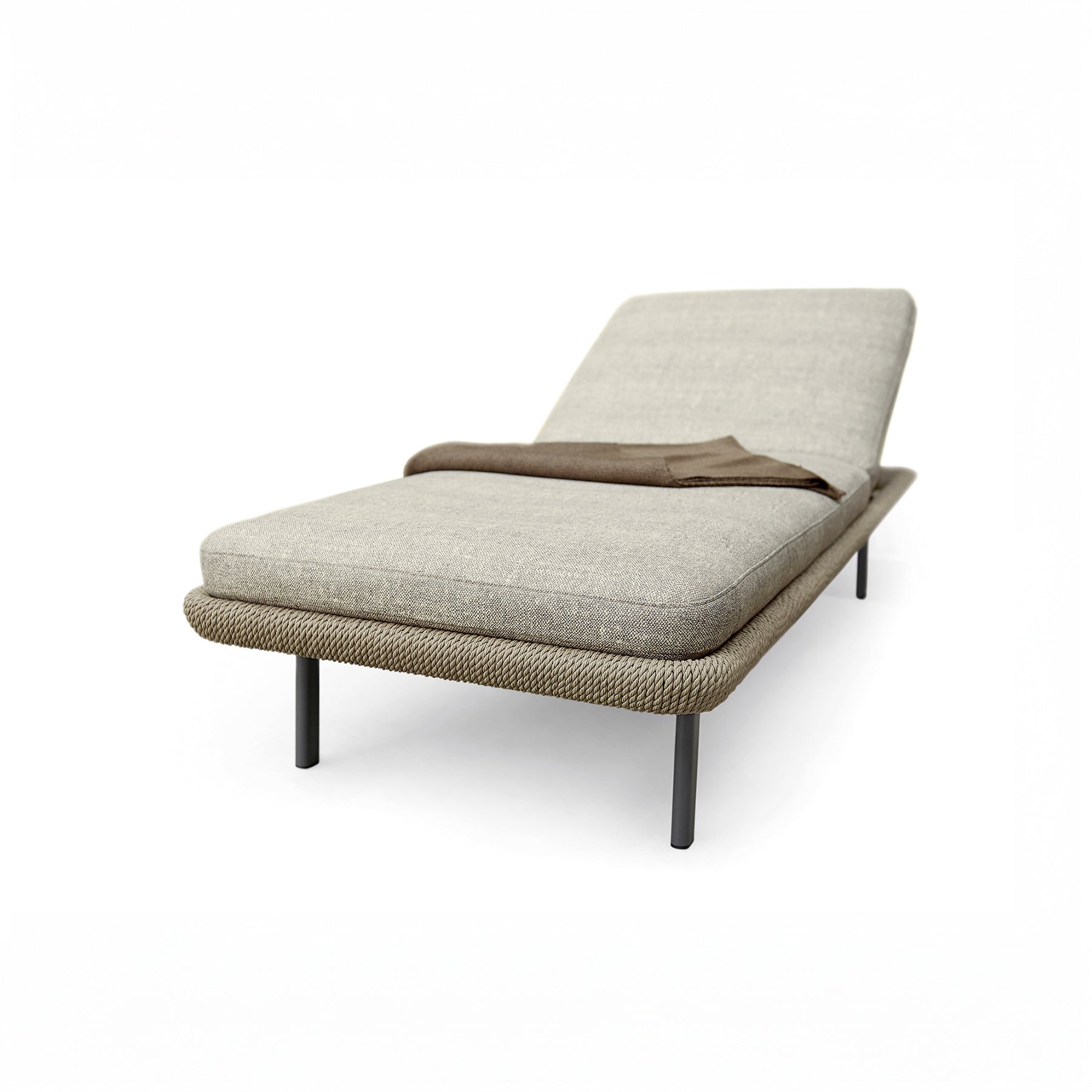 Modern lounge chair with beige cushion and brown blanket on a white background