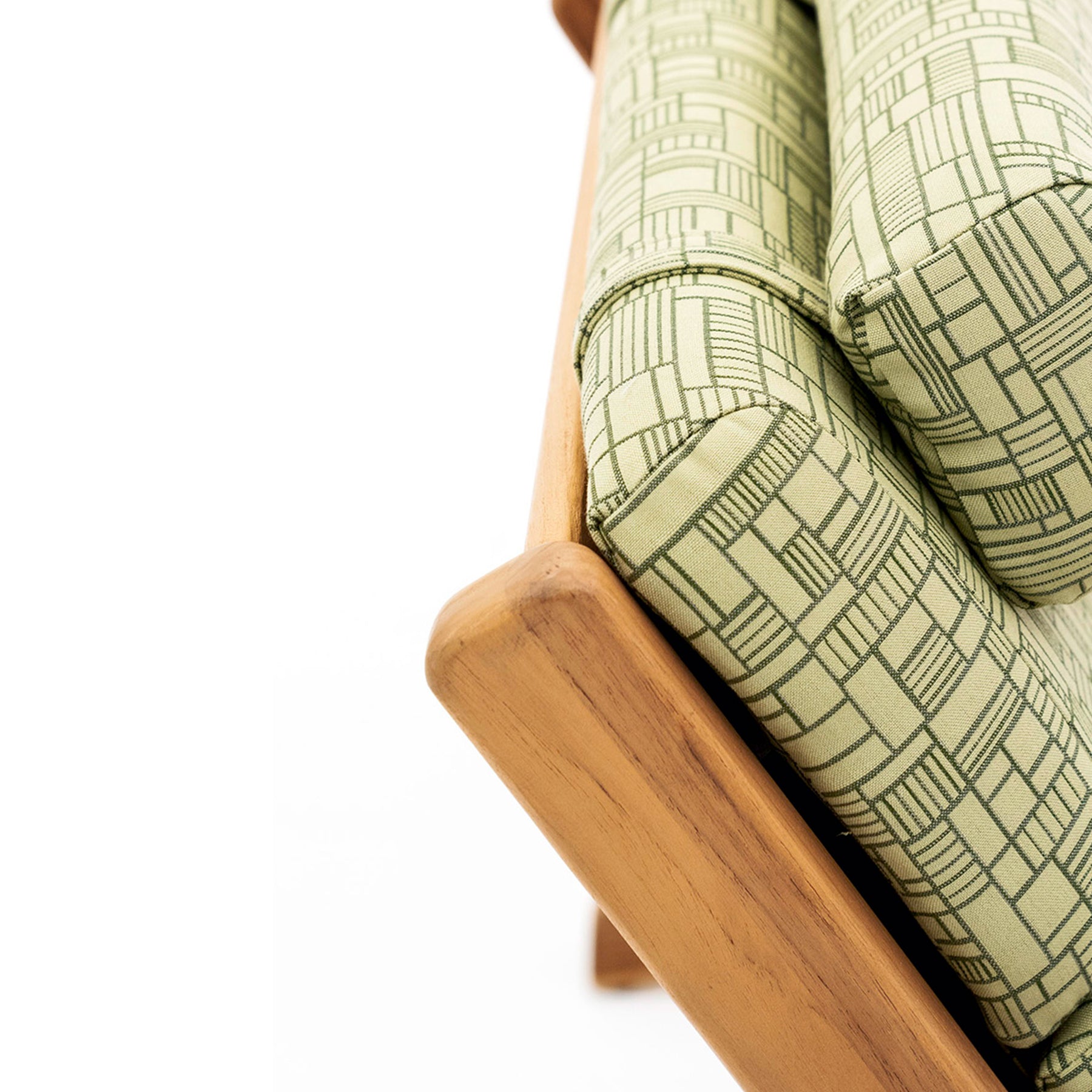 Close-up of a wooden chair with green patterned cushions on a white background