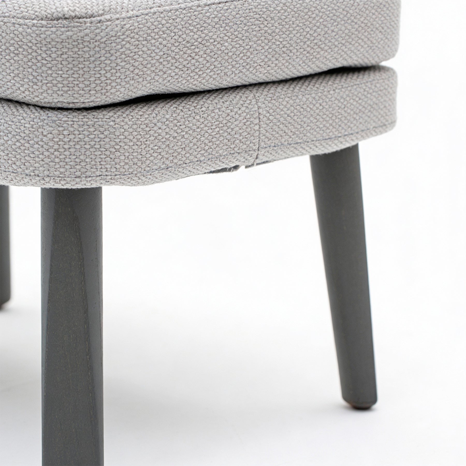 EMMA_FOOT Gray upholstered stool with dark legs on a white background