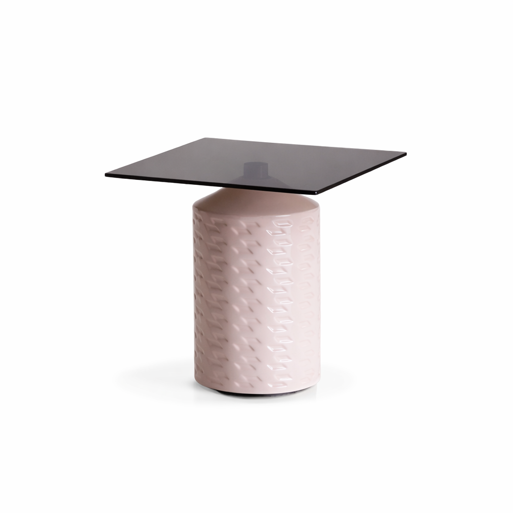 Side table with pink textured base and dark glass top on a white background