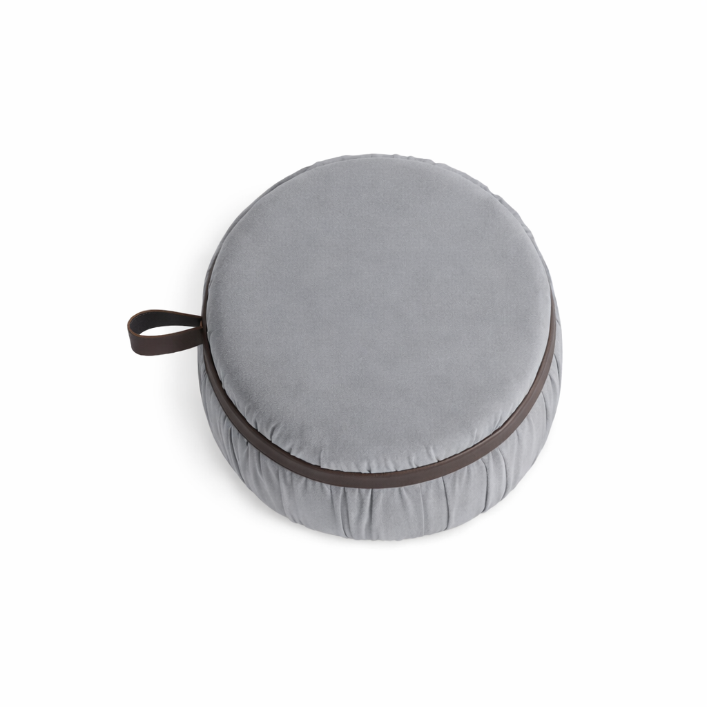 Gray round cushion with a brown handle on a white background
