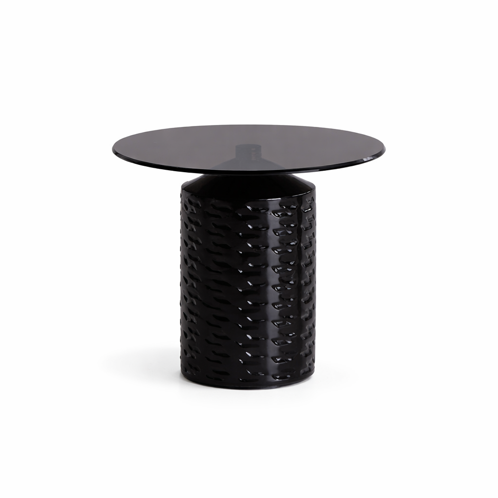 Black side table with textured cylindrical base and round glass top on a white background